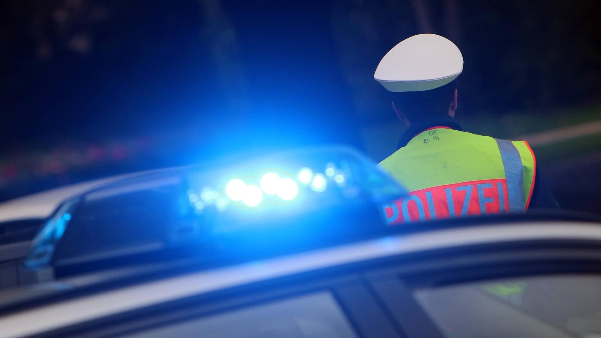 Polizist mit Mütze und Warnweste steht neben einem Einsatzwagen der Polizei: Anwohner hatten die Männer bei ihrer Tat beobachtet. Polizist mit Mütze und Warnweste steht neben einem Einsatzwagen der Polizei: Anwohner hatten die Männer bei ihrer Tat beobachtet.