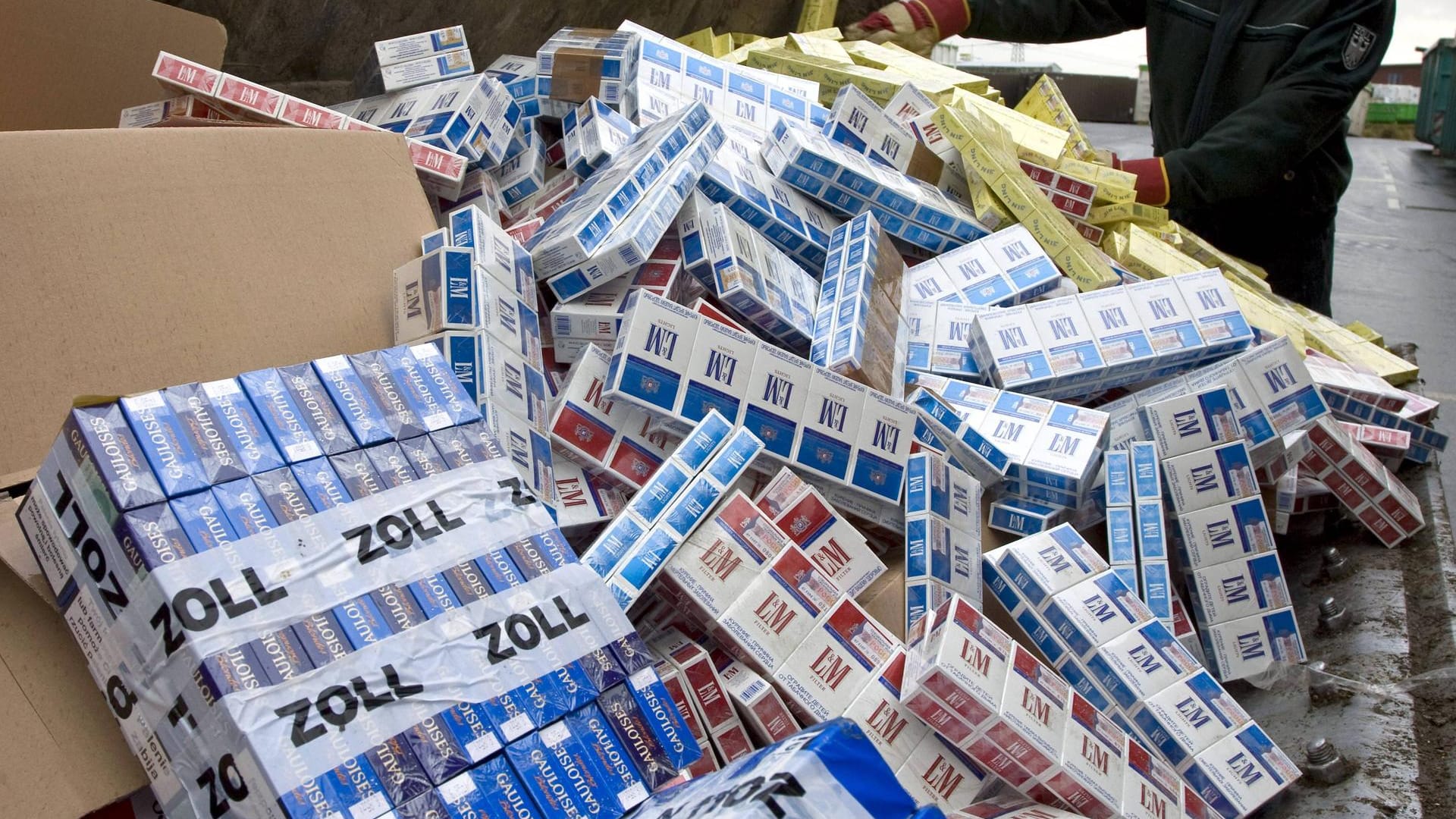 Ein Zollbeamter mit beschlagtnahmten Zigaretten: Der nun festgenommene Schmuggler barchte Millionen Zigaretten illegal ins Land. Ein Zollbeamter mit beschlagtnahmten Zigaretten: Der nun festgenommene Schmuggler barchte Millionen Zigaretten illegal ins Land.