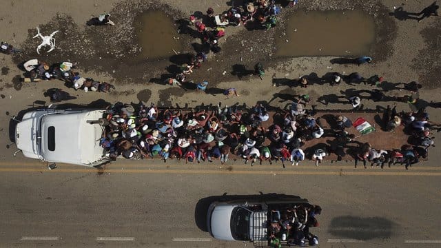 Migranten klettern in Mexiko auf den Anhänger eines Lastwagens, um weiter Richtung Norden zu fahren. Migranten klettern in Mexiko auf den Anhänger eines Lastwagens, um weiter Richtung Norden zu fahren.