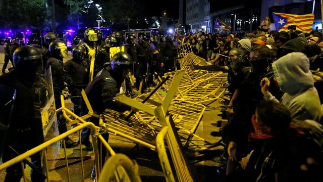 Pro-Unabhängigkeits-Demonstranten überwinden Barrieren zwischen ihnen und der Polizei. Pro-Unabhängigkeits-Demonstranten überwinden Barrieren zwischen ihnen und der Polizei.