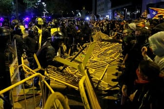 Pro-Unabhängigkeits-Demonstranten überwinden Barrieren zwischen ihnen und der Polizei.