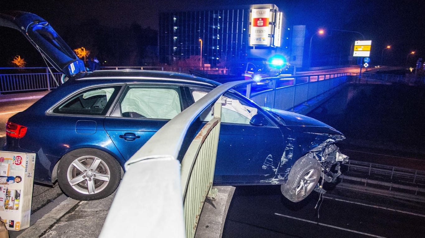 Ein Auto steckt im Geländer einer Brücke: Die Beifahrerin des Wagens wollte verhindern, dass abgesplitterte Autoteile weitere Unfälle auslösen.