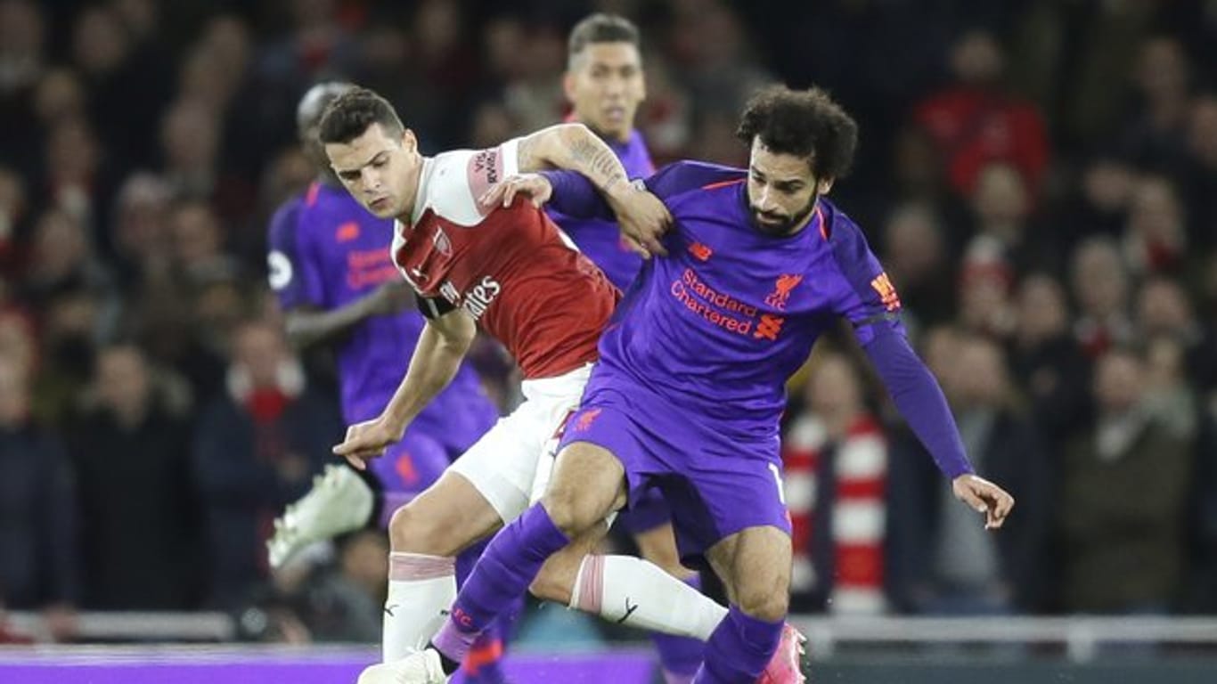 Arsenals Granit Xhaka (l) im Zweikampf mit Liverpools Mohamed Salah.