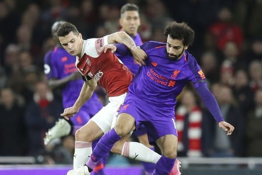 Arsenals Granit Xhaka (l) im Zweikampf mit Liverpools Mohamed Salah.