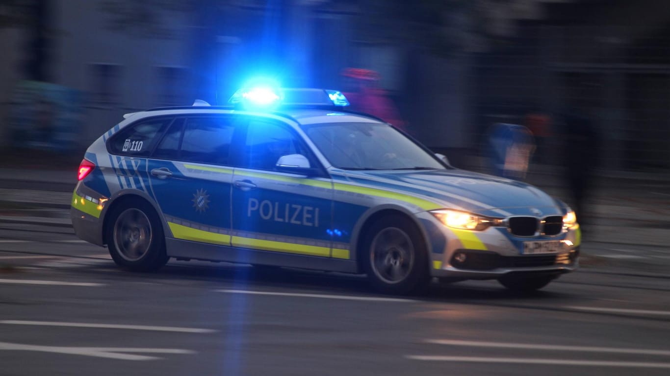 Einsatzwagen der Polizei mit eingeschaltetem Blaulicht bei einem Einsatz in der Innenstadt München