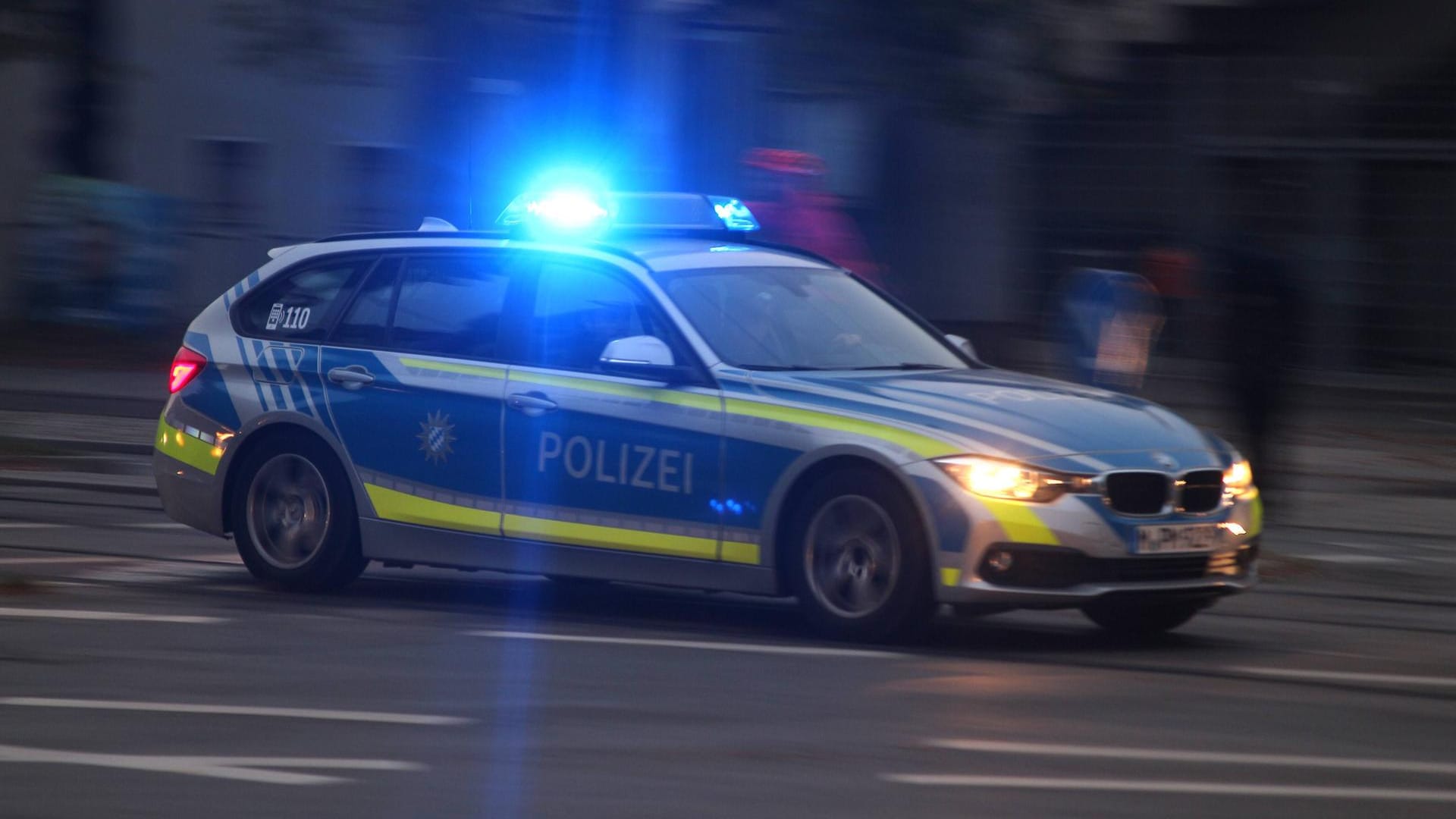 Einsatzwagen der Polizei mit eingeschaltetem Blaulicht bei einem Einsatz in der Innenstadt München Einsatzwagen der Polizei mit eingeschaltetem Blaulicht bei einem Einsatz in der Innenstadt München