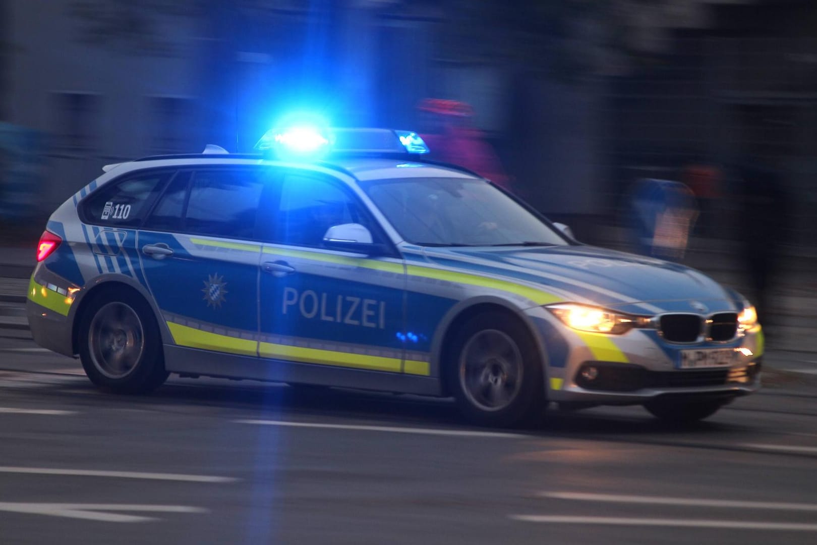Einsatzwagen der Polizei mit eingeschaltetem Blaulicht bei einem Einsatz in der Innenstadt München