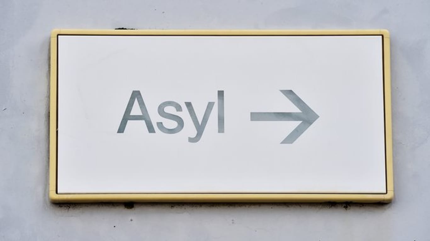 Ein Schild mit der Aufschrift "Asyl" hängt in einer Landeserstaufnahme für Asylbewerber (LEA) an einer Wand.