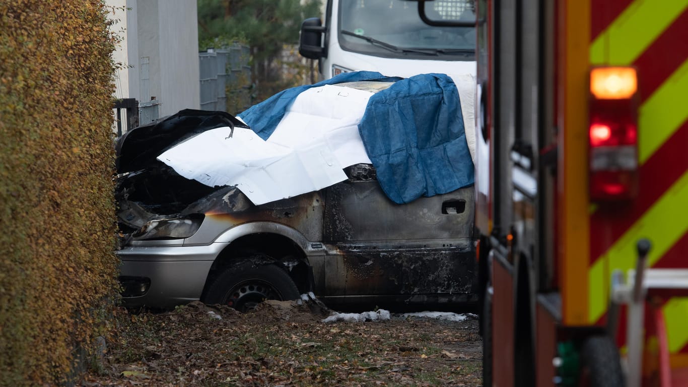 Ein ausgebranntes Auto ist mit Tüchern bedeckt: Das Fahrzeug war aus bislang ungeklärten Ursachen in Flammen aufgegangen.