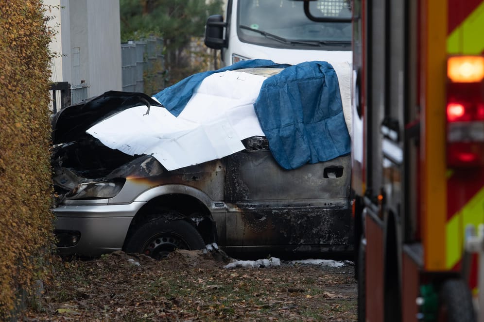 Ein ausgebranntes Auto ist mit Tüchern bedeckt: Das Fahrzeug war aus bislang ungeklärten Ursachen in Flammen aufgegangen.