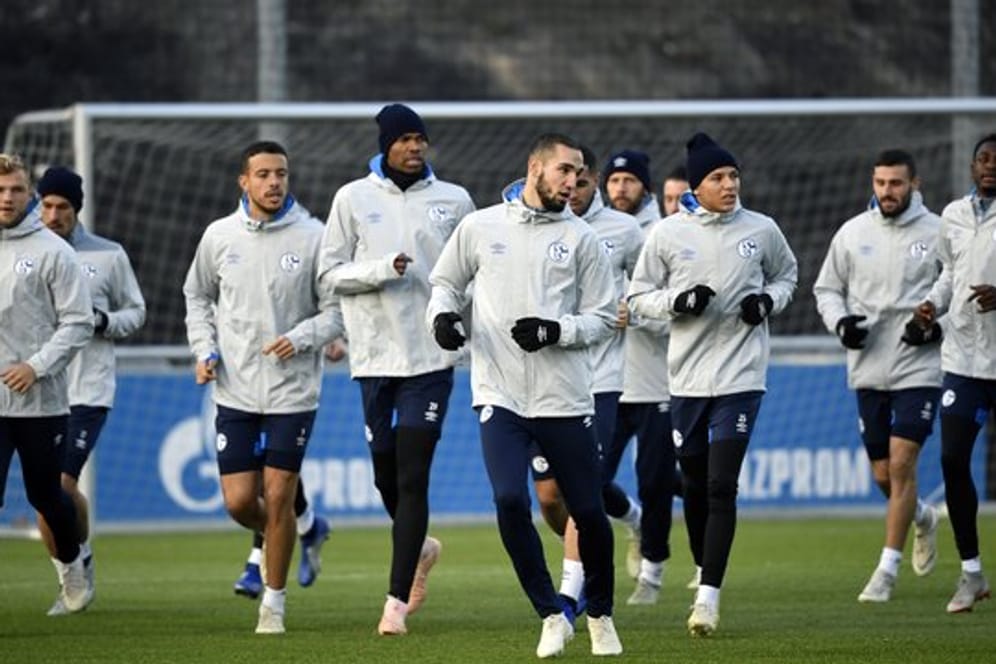 Die Stimmung hat sich verbessert: Schalkes Spieler laufen sich beim Training auf dem Trainingsgelände warm.