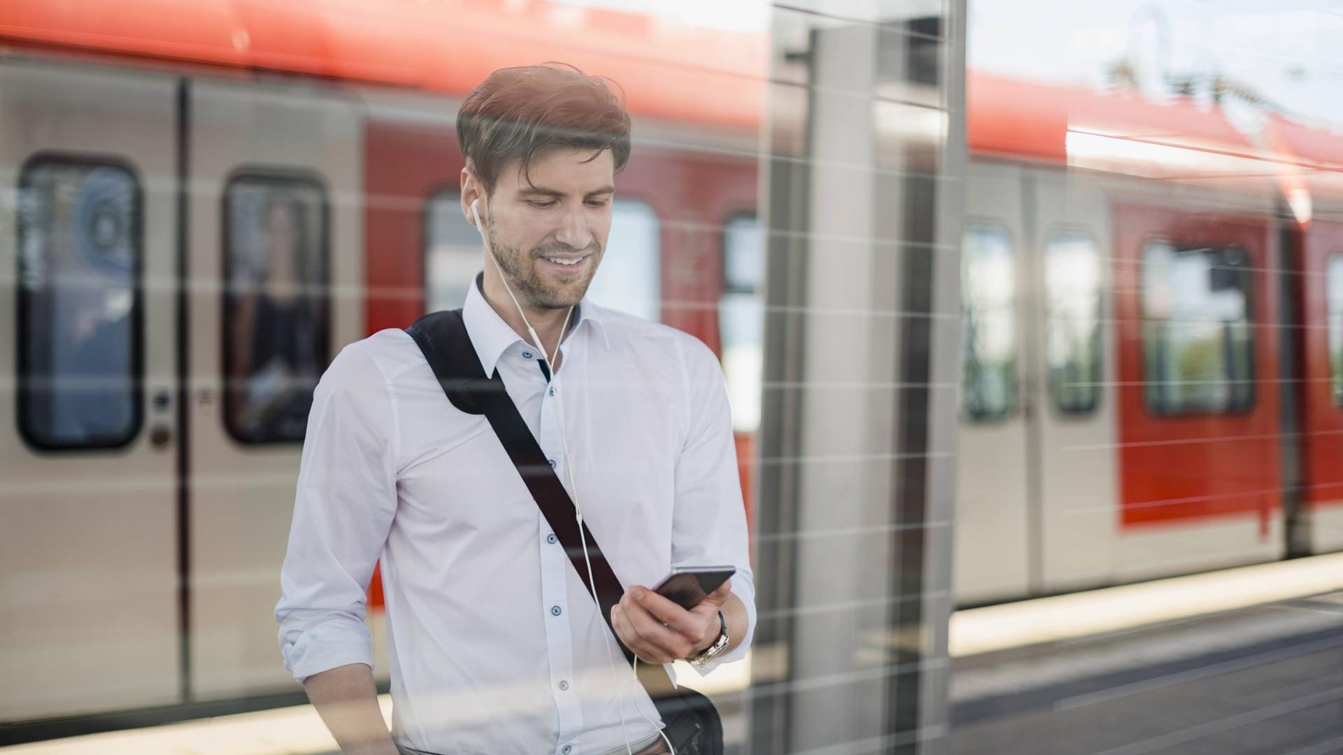 Ein Pendler schaut auf sein Smartphone: Wenn das Datenvolumen aufgebraucht ist, wird die Surfgeschwindigkeit bei vielen Tarifen so stark gedrosselt, dass die meisten Anwendungen unbenutzbar sind.