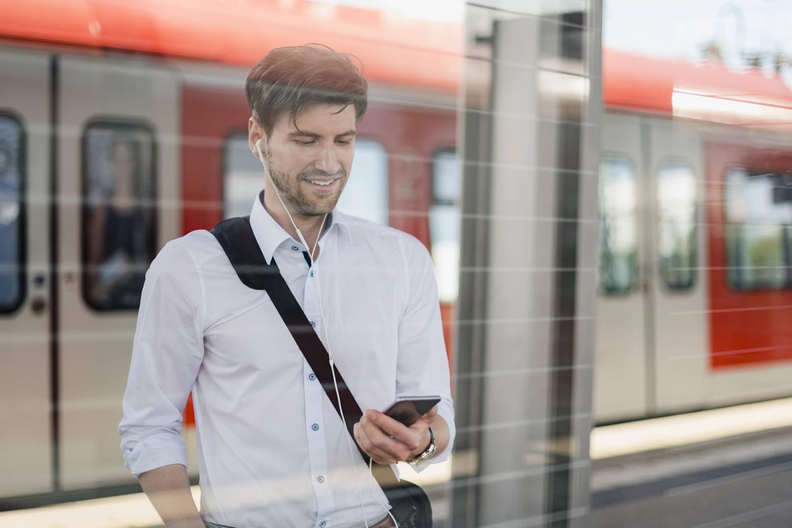 Ein Pendler schaut auf sein Smartphone: Wenn das Datenvolumen aufgebraucht ist, wird die Surfgeschwindigkeit bei vielen Tarifen so stark gedrosselt, dass die meisten Anwendungen unbenutzbar sind.