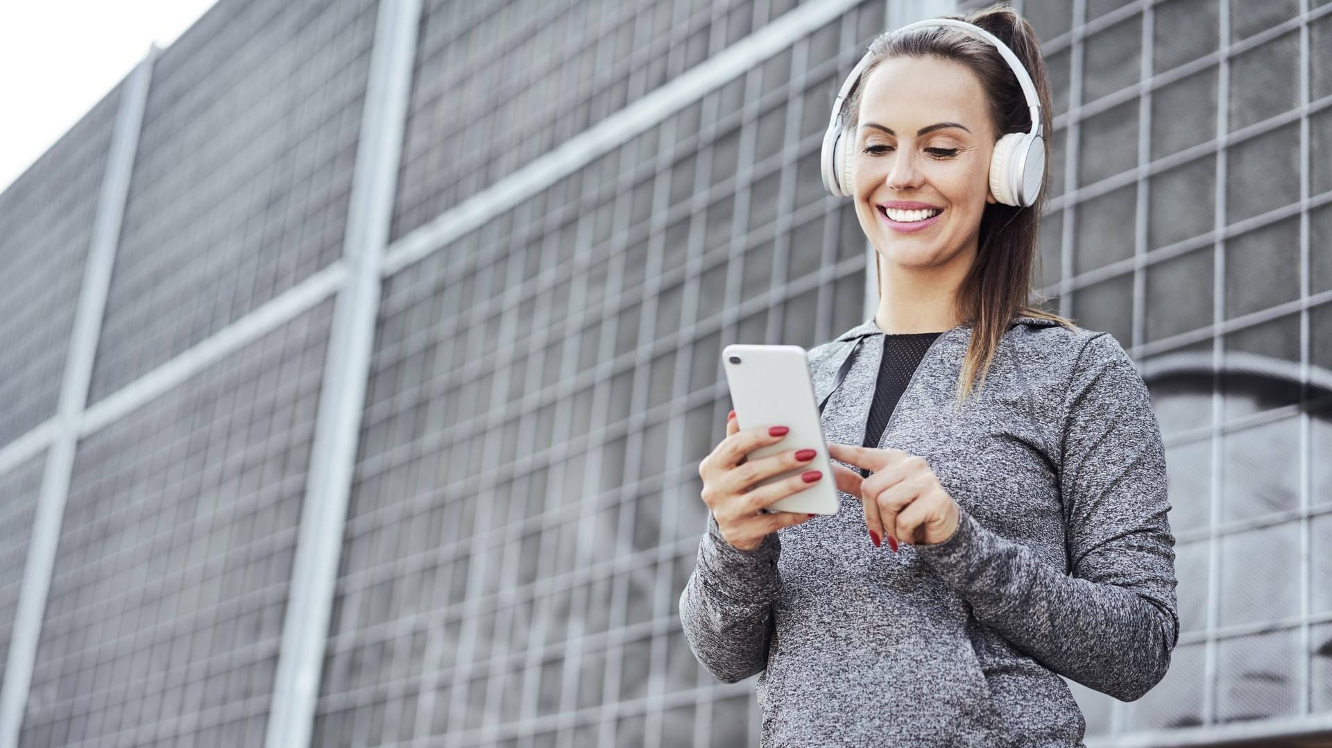 Eine Frau streamt Musik über ihr Smartphone: Die Telekom hat weitere Partner in ihr Streaming-Angebot "StreamOn" aufgenommen.