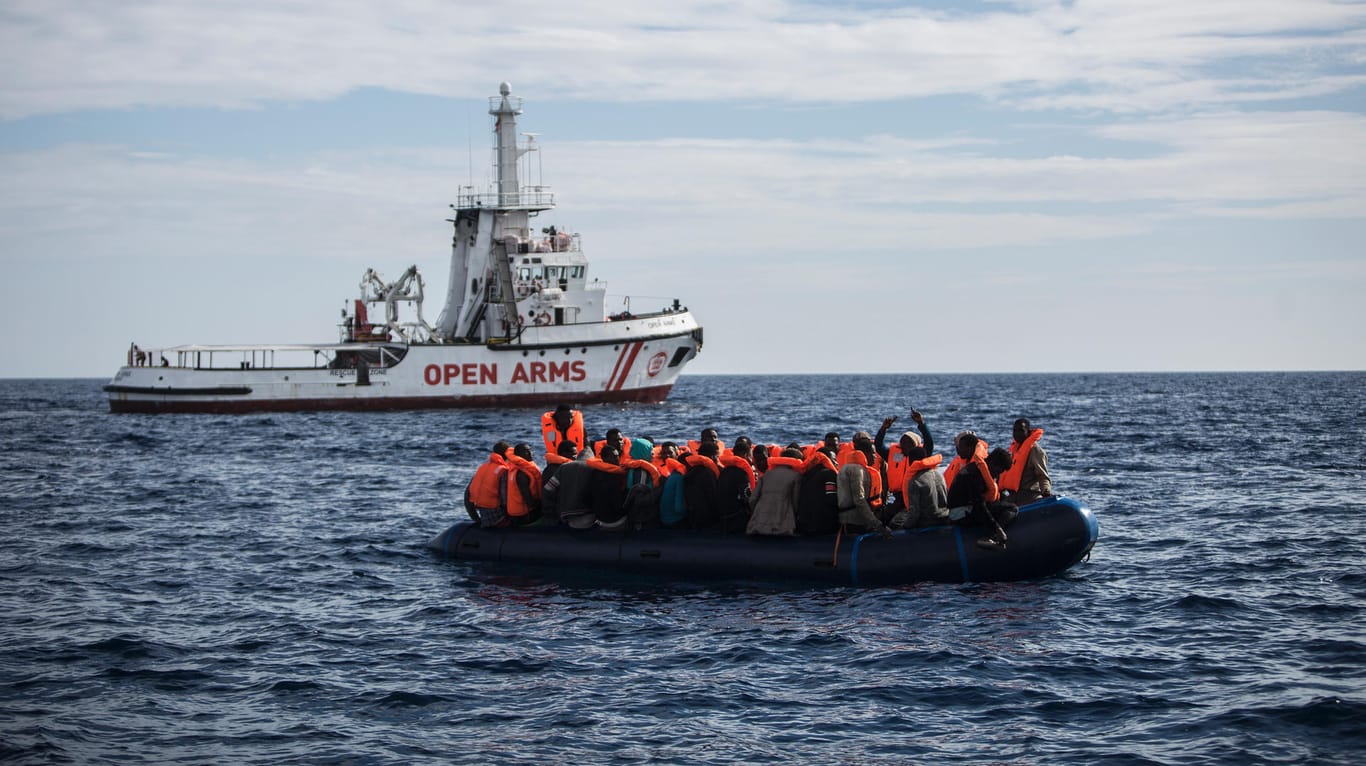 Flüchtlinge auf einem Schlauchboot freuen sich über die Ankunft eines Rettimgsschiffes: Mehr als 2.000 Menschen ertranken in diesem Jahr im Mittelmeer. (Archivbild)