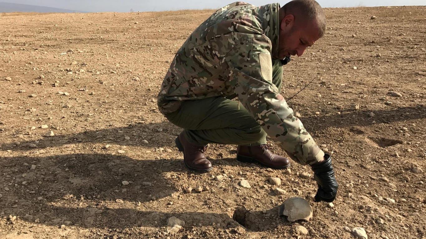 Spuren des IS-Terrors: Chokor Melhem Elias von der hiesigen Armee legt in Sindschar Reste eines menschlichen Schädels frei.