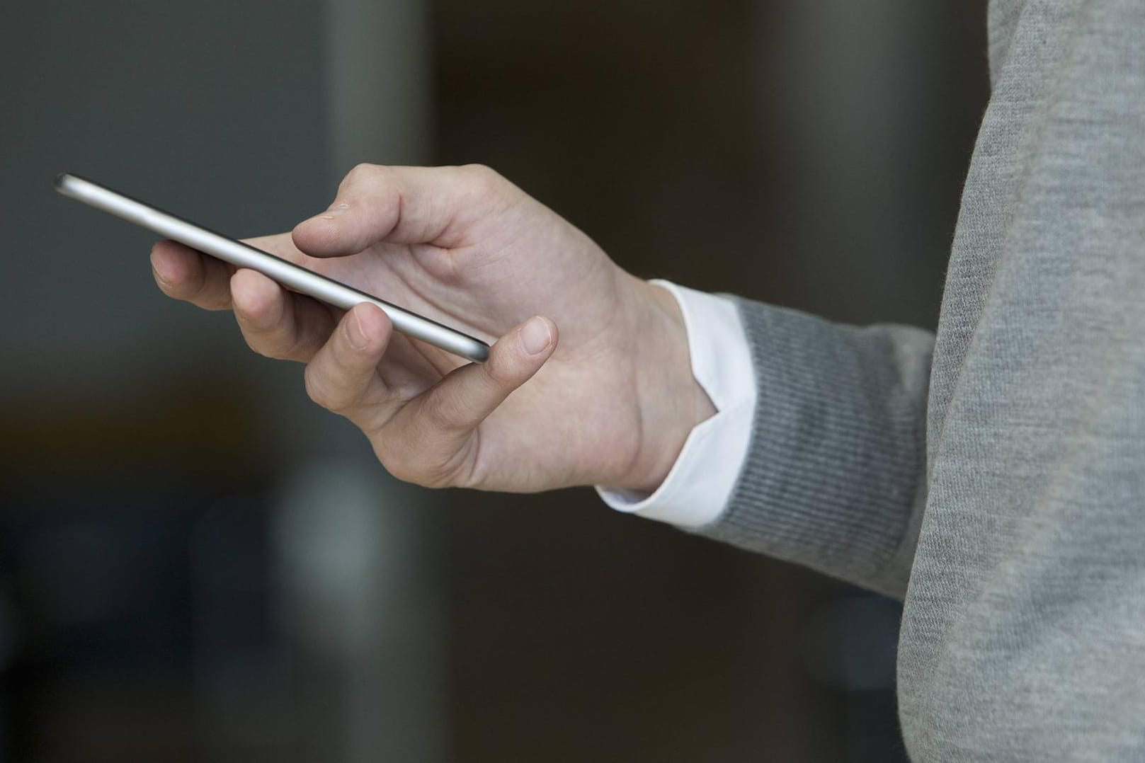 Ein Smartphone in einer Hand: Einige der überprüften Handys waren offenbar manipuliert. (Symbolbild)