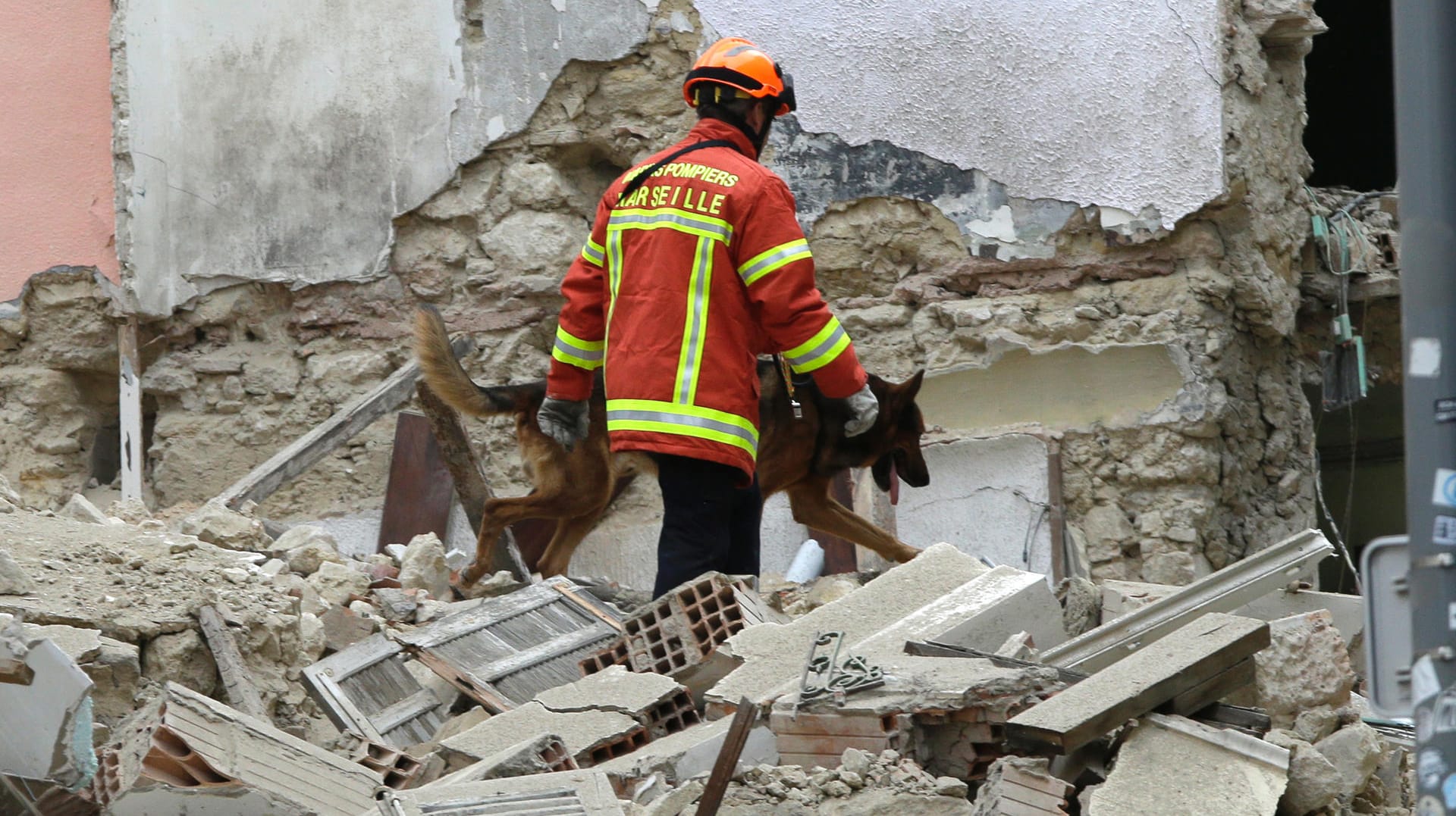 Ein Feuerwehrmann sucht mit einem Spürhund nach Überlebenden: In Marseille sind zwei Häuser eingestürzt. Bisher wurden fünf Tote gebogen.