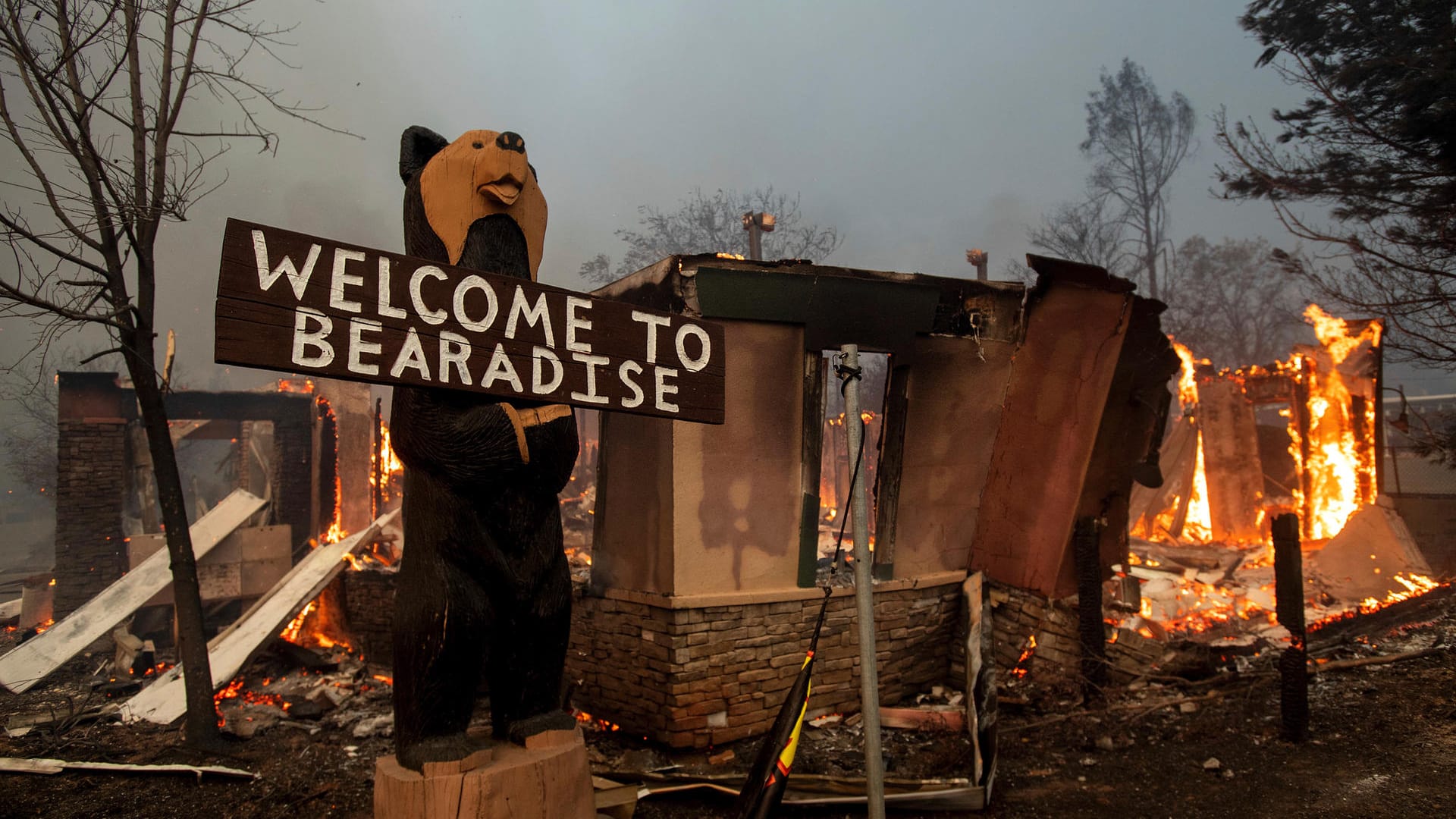 Ein Ortsschild von Paradise: Ein Gebäude steht in Flammen, während sich das Feuer durch die Stadt bewegt.