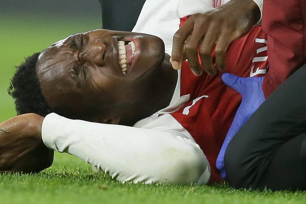 Mit schmerzverzerrtem Gesicht liegt Danny Welbeck am Boden: Dem Stürmer des FC Arsenal droht eine lange Verletzungspause.
