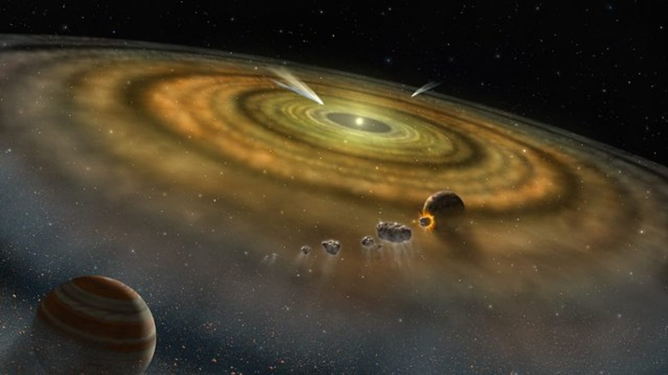 Gas und Staub umkreisen in einem jungen Planetensystem eine Sonne.