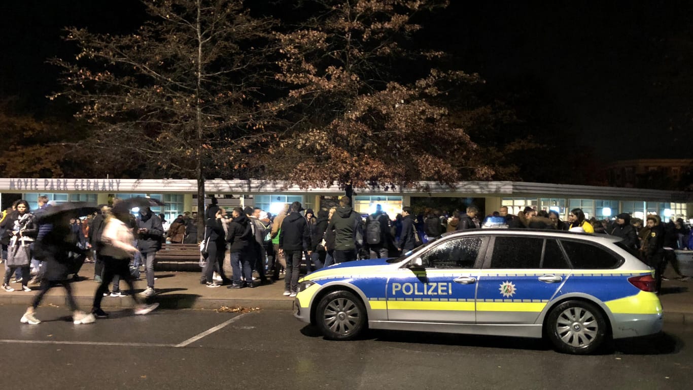 Ein Polizeiwagen und zahlreiche Menschen stehen vor dem Eingang des Movie Parks Germany: Nach einer Bombendrohung hat die Polizei den Freizeitpark geräumt.