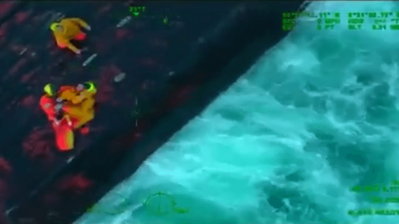 Rettungskräfte holen die Fischer von dem gekenterten Boot: Die Küstenwache filmte den dramatischen Einsatz.