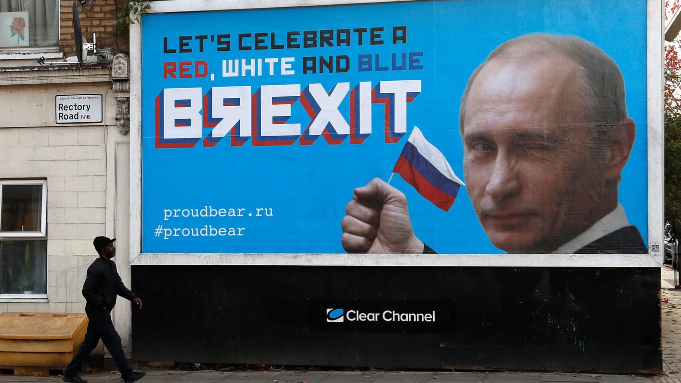 Ein Passant vor der Putin-Plakatwand: Eine Gruppe namens "Proudbear" hat die Plakate aufgestellt – aus einem ganz bestimmten Grund.