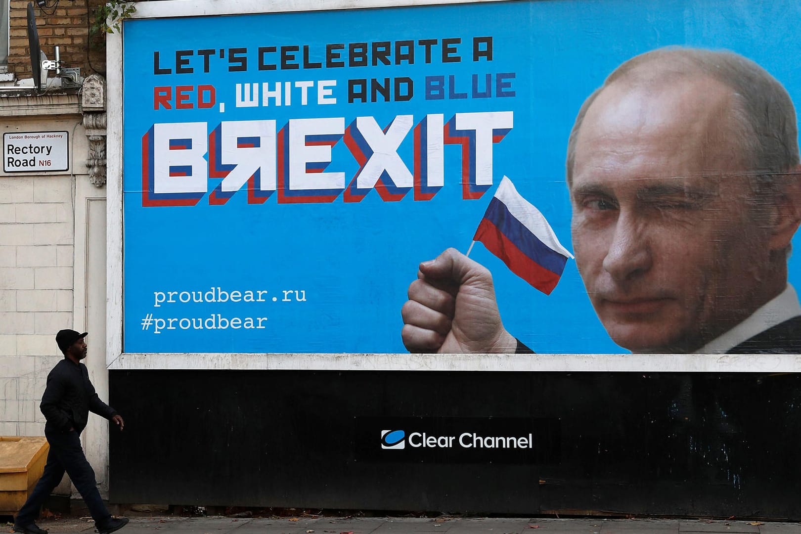 Ein Passant vor der Putin-Plakatwand: Eine Gruppe namens "Proudbear" hat die Plakate aufgestellt – aus einem ganz bestimmten Grund.