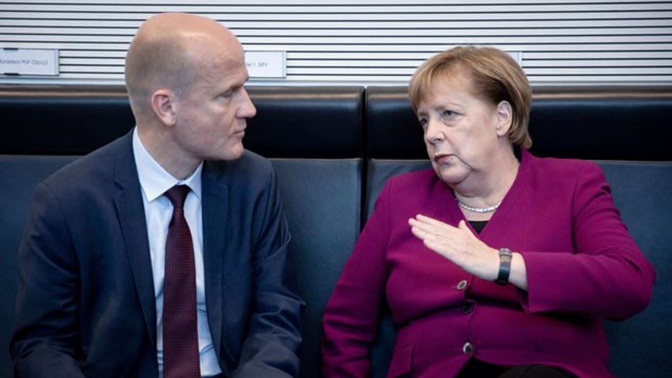 Bundeskanzlerin Angela Merkel (CDU) und Ralph Brinkhaus, CDU/CSU-Fraktionsvorsitzender im Bundestag, unterhalten sich.