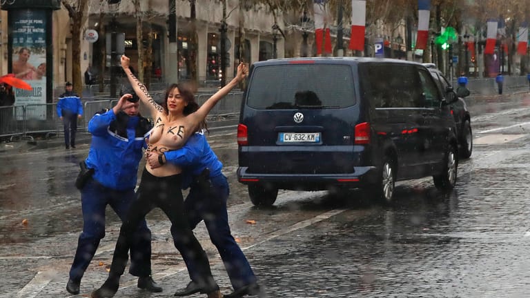 Femen-Aktivistin im Einsatz: Nachdem die Demonstrantin von Sicherheitsleuten festgenommen wurde, konnte die Kolonne weiterfahren.