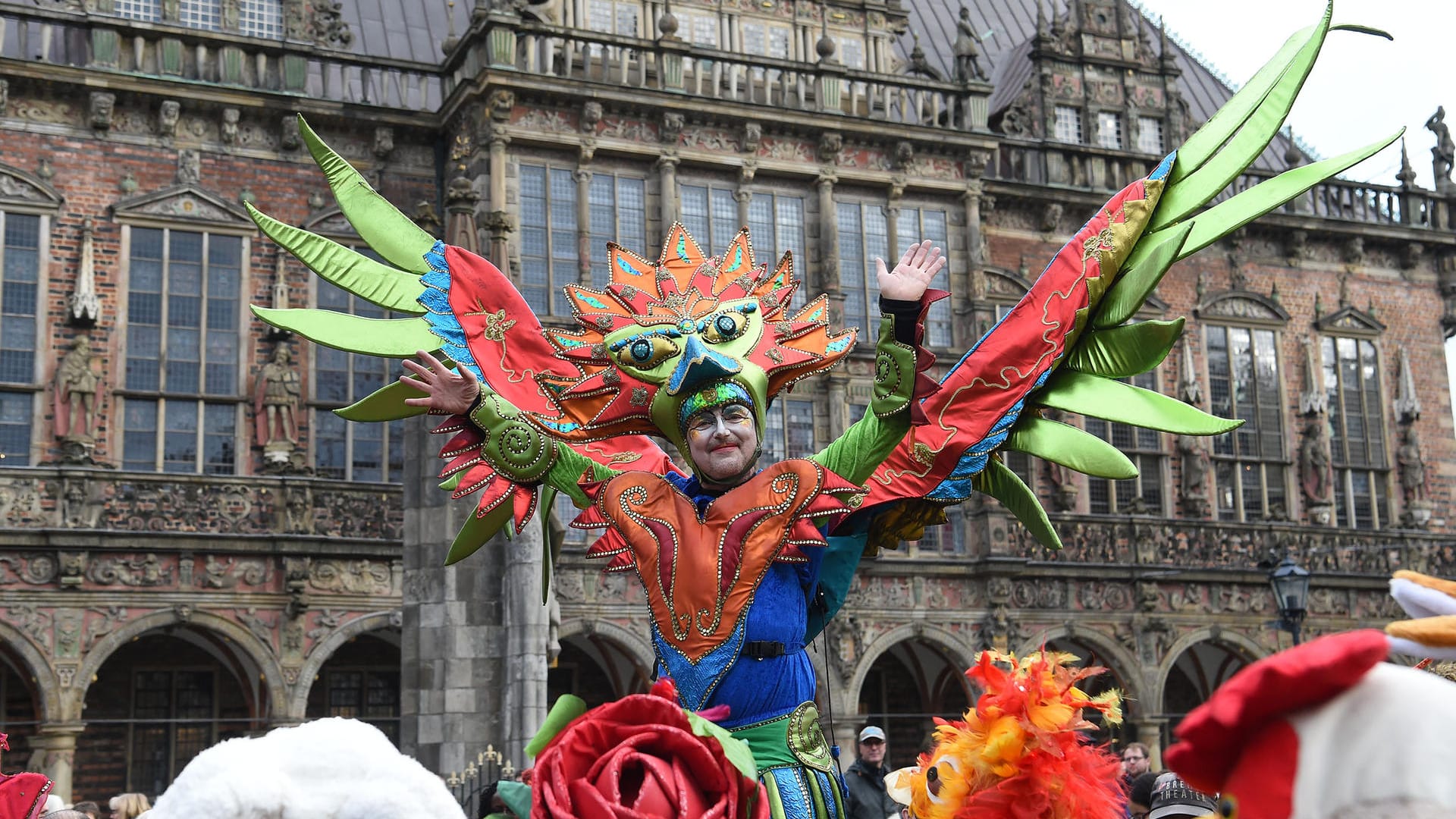 Akteure des Samba-Karnevals ziehen über den Marktplatz, im Hintergrund das Bremer Rathaus: Tänzer, Maskenspieler und Stelzenläufer starten auch in Bremen in die Zeit des Frohsinns.