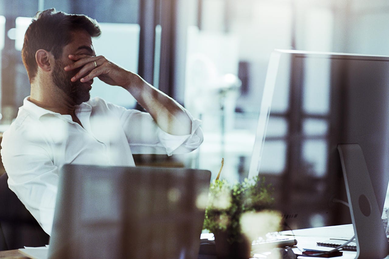 Angestellter am Schreibtisch: Welche Arbeiten der Arbeitnehmer zu erledigen hat, regelt der Arbeitsvertrag. Ob eng umrissen oder weiter gefasst – es gibt Vor- und Nachteile.