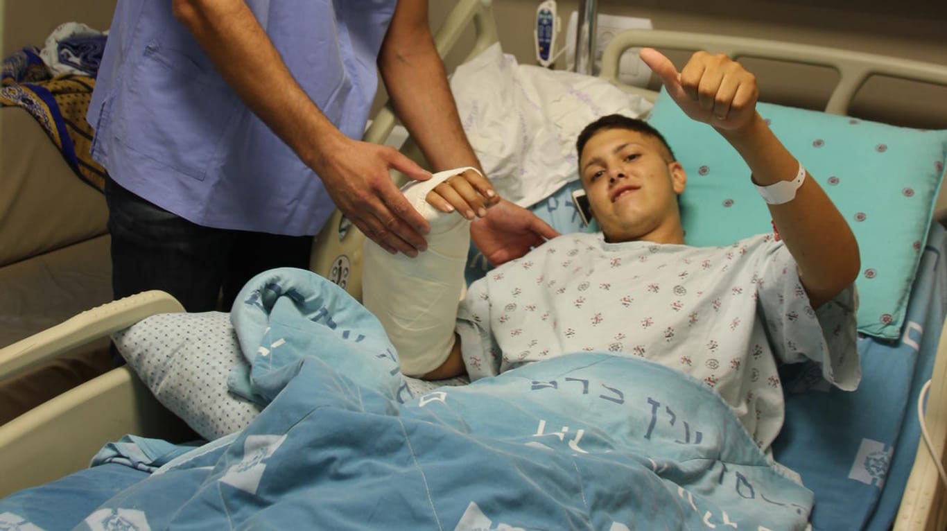 Der Handchirurg steht im Jerusalemer Hadassah-Krankenhaus neben seinem 20-jährigen Patienten: Ob der Arm wieder voll funktionsfähig wird, ist nicht klar – der tapfere Patient ist trotzdem wieder am Lächeln.