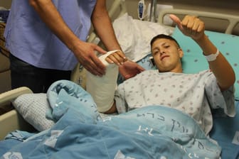 Der Handchirurg steht im Jerusalemer Hadassah-Krankenhaus neben seinem 20-jährigen Patienten: Ob der Arm wieder voll funktionsfähig wird, ist nicht klar – der tapfere Patient ist trotzdem wieder am Lächeln.