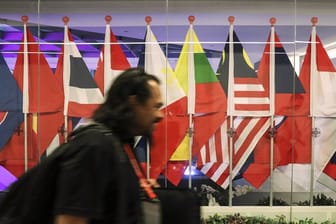 Ein Journalist passiert in Singapur die Flaggen von teilnehmenden Ländern des Asean-Gipfels.