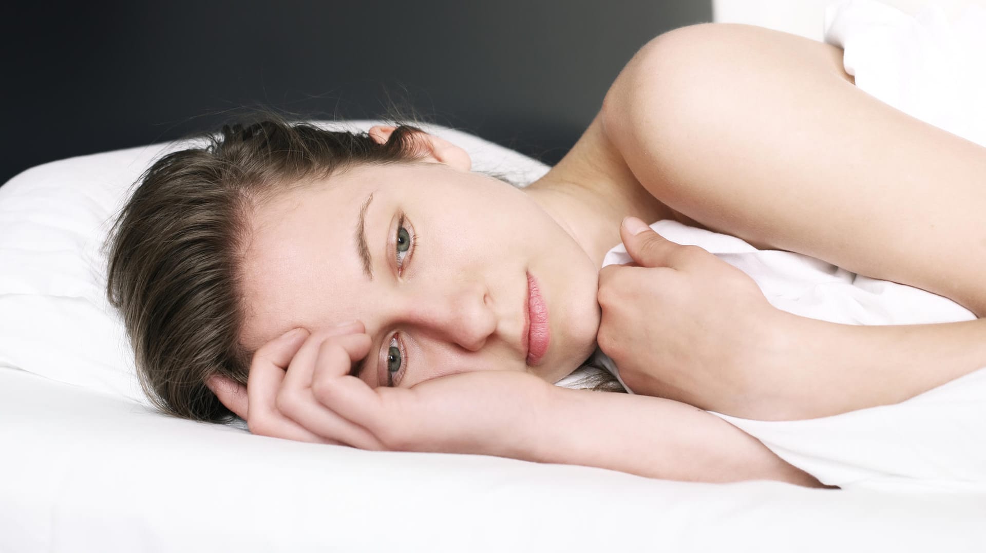 Frau nackt im Bett mit Decke