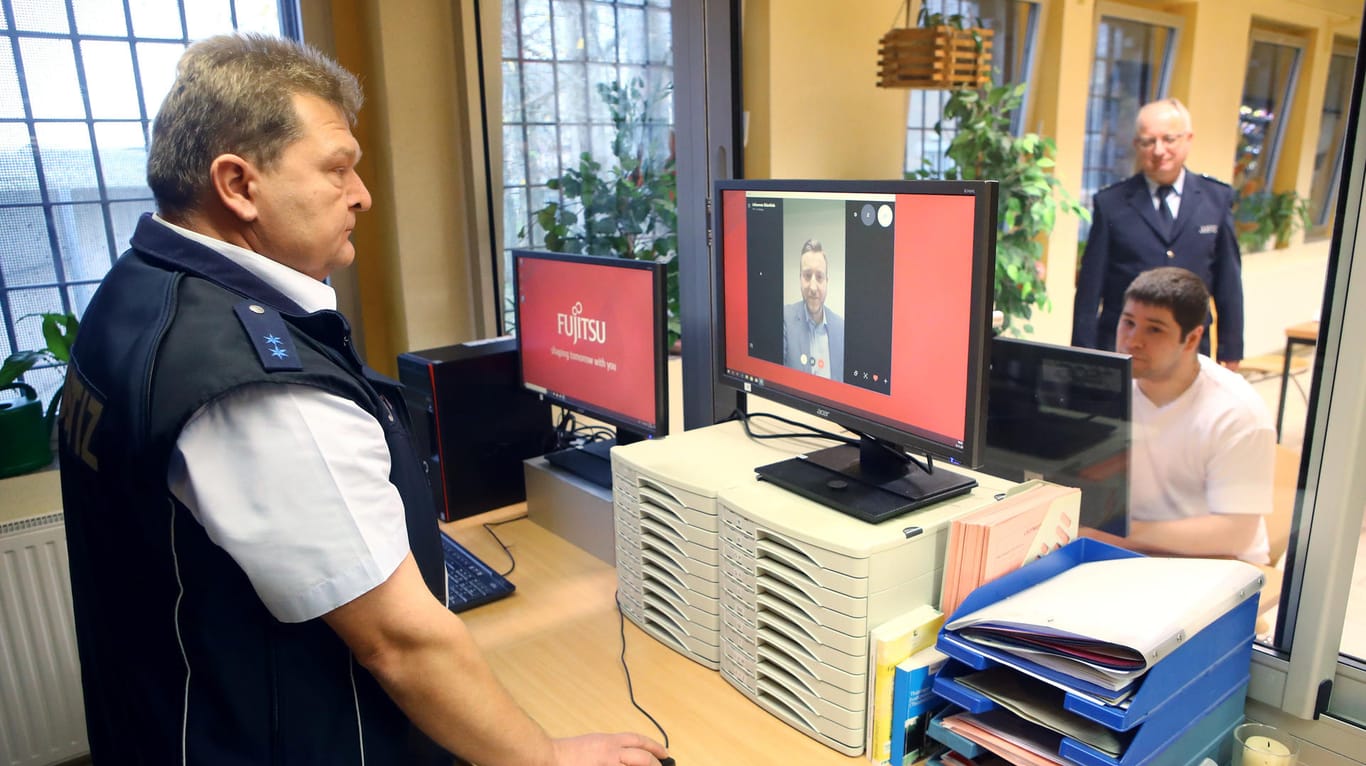 Ein Justizbeamter überwacht das Skype-Gespräch eines Strafgefangenen: An einem separaten Bildschirm wird überprüft, ob sich unangemeldete Personen am Gespräch beteiligen.