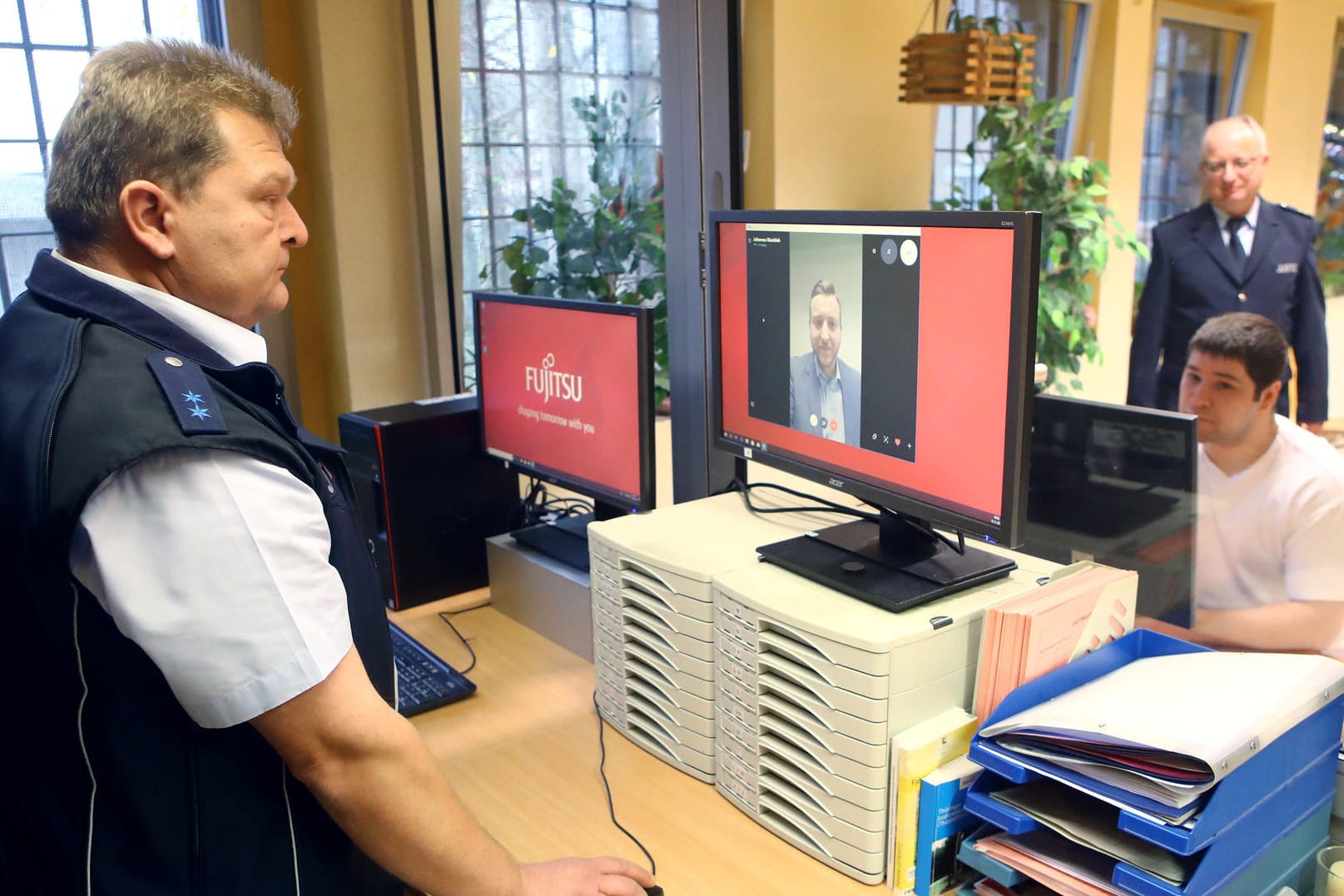Ein Justizbeamter überwacht das Skype-Gespräch eines Strafgefangenen: An einem separaten Bildschirm wird überprüft, ob sich unangemeldete Personen am Gespräch beteiligen.