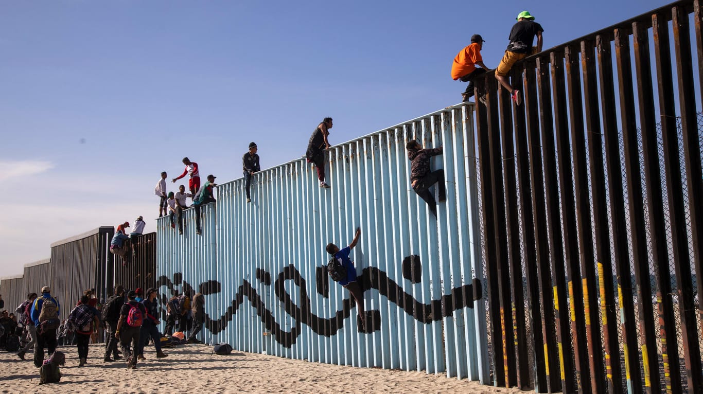 Endlich am Ziel: Migranten aus Mittelamerika sitzen auf dem Grenzzaun zwischen Mexiko und den USA.