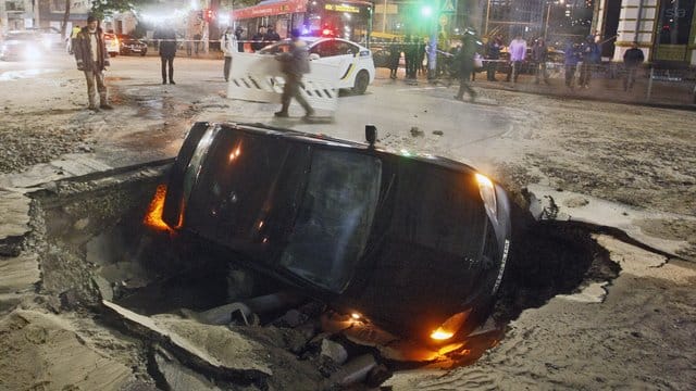 Wegen eines Rohrbruchs ist ein Auto mitten in der ukrainischen Hauptstadt Kiew in einer Straße eingebrochen. Wegen eines Rohrbruchs ist ein Auto mitten in der ukrainischen Hauptstadt Kiew in einer Straße eingebrochen.