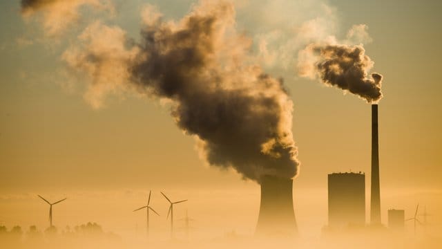 Vergangenheit und Zukunft: Windräder drehen sich hinter einem Kohlekraftwerk. Vergangenheit und Zukunft: Windräder drehen sich hinter einem Kohlekraftwerk.