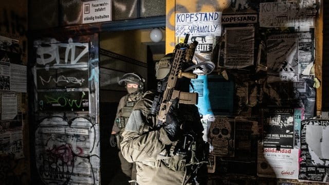 SEK-Beamte gehen bei einer Razzia in der Rigaer Straße in Berlin-Friedrichshain aus einem Haus. SEK-Beamte gehen bei einer Razzia in der Rigaer Straße in Berlin-Friedrichshain aus einem Haus.