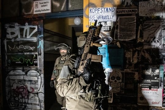 SEK-Beamte gehen bei einer Razzia in der Rigaer Straße in Berlin-Friedrichshain aus einem Haus.