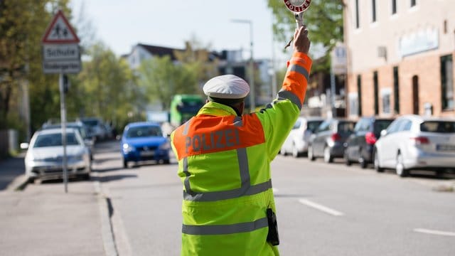 Ein Polizist hält im Rahmen einer Geschwindigkeitsmessung einen Autofahrer an. Ein Polizist hält im Rahmen einer Geschwindigkeitsmessung einen Autofahrer an.