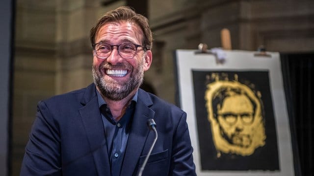 Jürgen Klopp freut sich nach der Preisverleihung über die goldene Druckgrafik mit seinem Porträt.