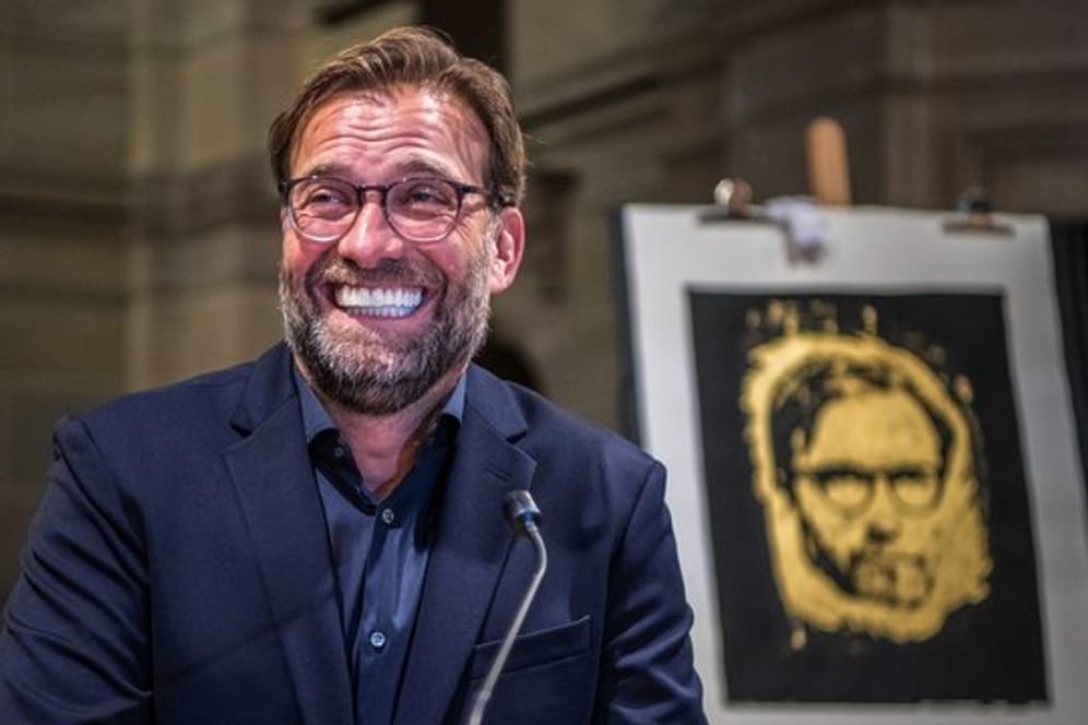 Jürgen Klopp freut sich nach der Preisverleihung über die goldene Druckgrafik mit seinem Porträt.