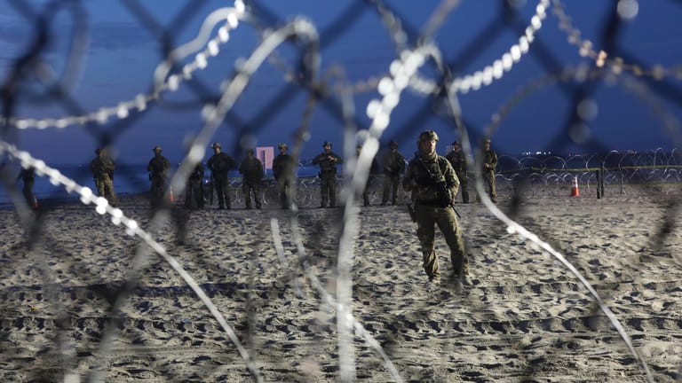Aufmarsch gegen die "Invasoren": US-Grenzsoldaten sind hinter dem stacheldrahtbewehrten Zaun am Strand nahe Tijuana postiert.