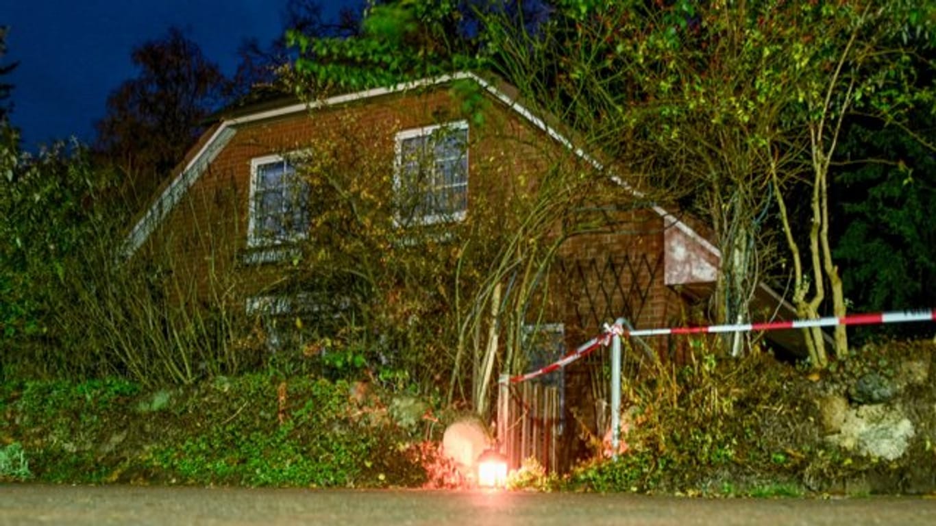 Eine Grableuchte steht neben einer Polizeiabsperrung am Eingang zu einem Haus in Wittenburg.