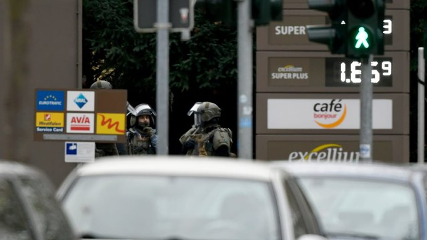 Schwer bewaffnete Polizisten stehen an einer Tankstelle im Bochumer Stadtteil Langendreer.